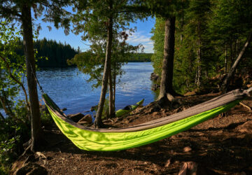 a hammock hangs in front of a kayak, on brule lake, in the boundery water canoe area wilderness, minnesota.