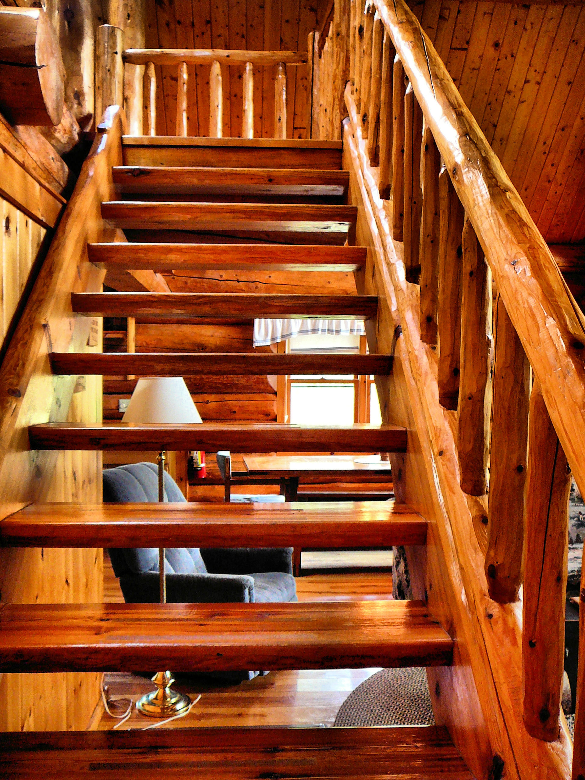 Log steps leading to loft area with chair seen between stair slats