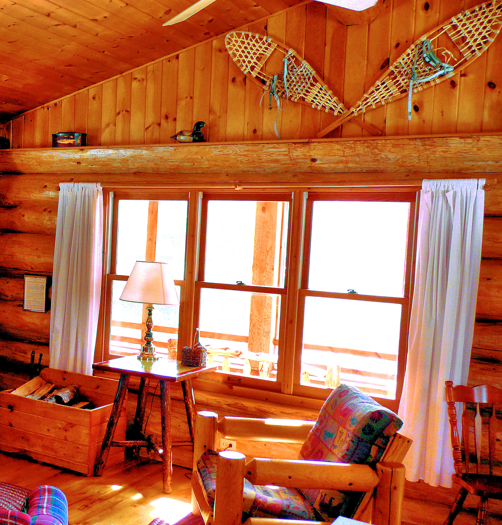 Window in a log cabin with snowshoes above