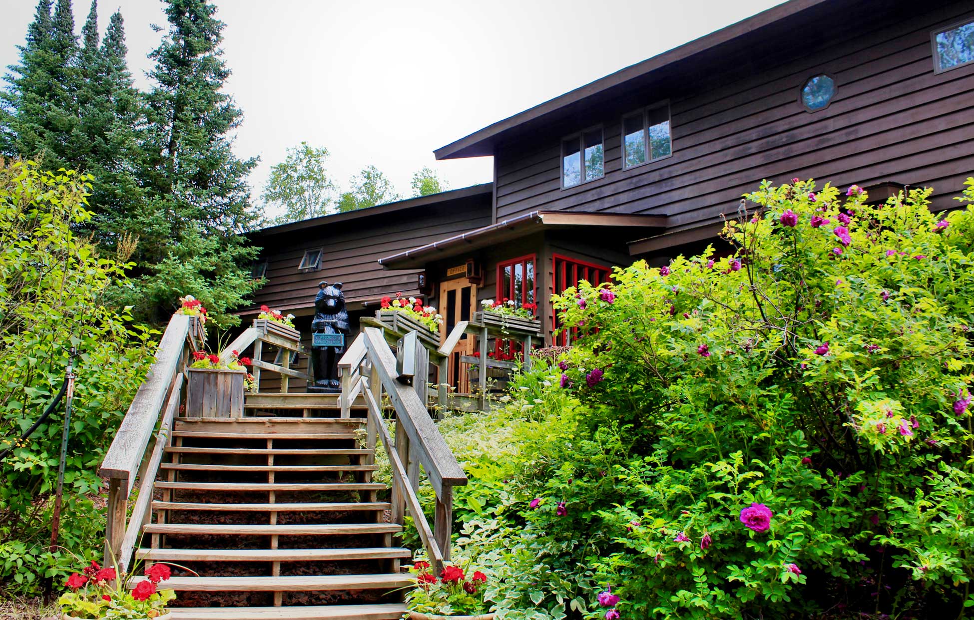 Front photo of Bearskin Lodge in the summer with flowers