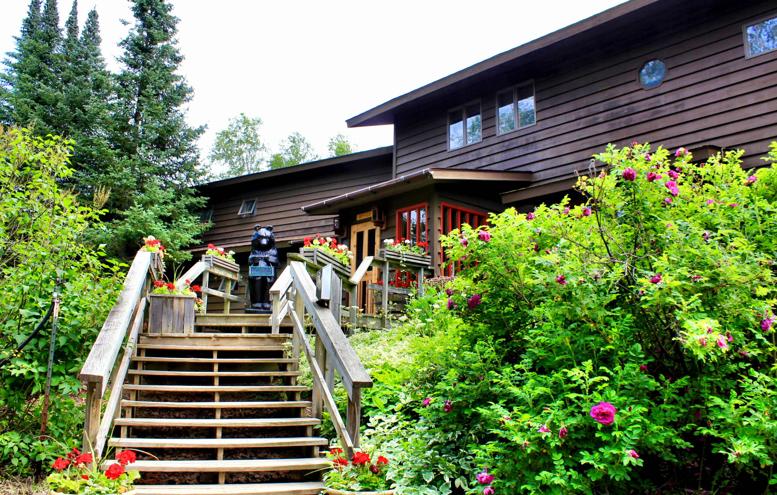 Stairs leading up to lodge with flower bushes in front