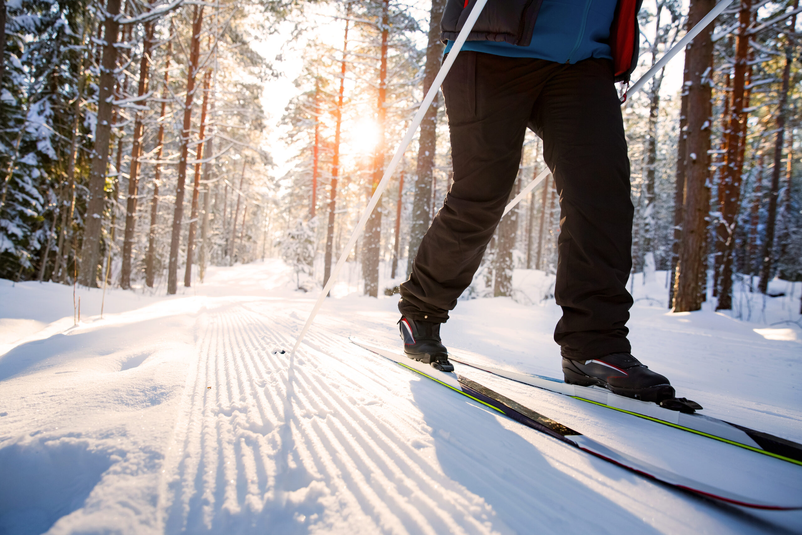 Close up shot of a person cross country skiing in the winter with sun setting in the background